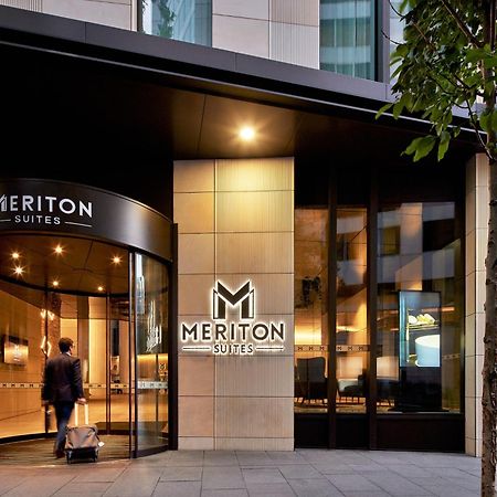 Meriton Suites Sussex Street, Sydney Ngoại thất bức ảnh The photo shows the entrance of a hotel or suite establishment named "Meriton Suites." The entrance features a revolving door and a large, illuminated sign with the name "MERITON SUITES." The facade is modern and sleek, with a combination of glass an