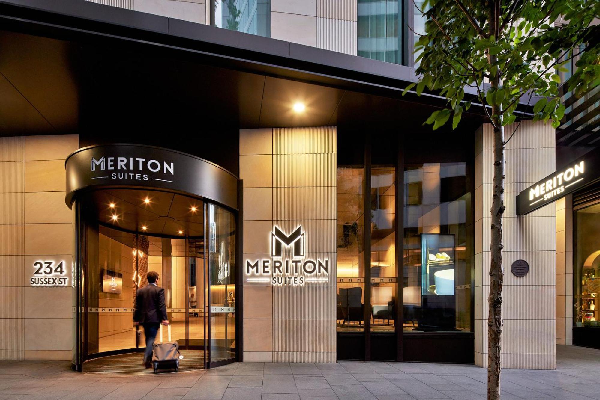 Meriton Suites Sussex Street, Sydney Ngoại thất bức ảnh The photo shows the entrance of a hotel or suite establishment named "Meriton Suites." The entrance features a revolving door and a large, illuminated sign with the name "MERITON SUITES." The facade is modern and sleek, with a combination of glass an