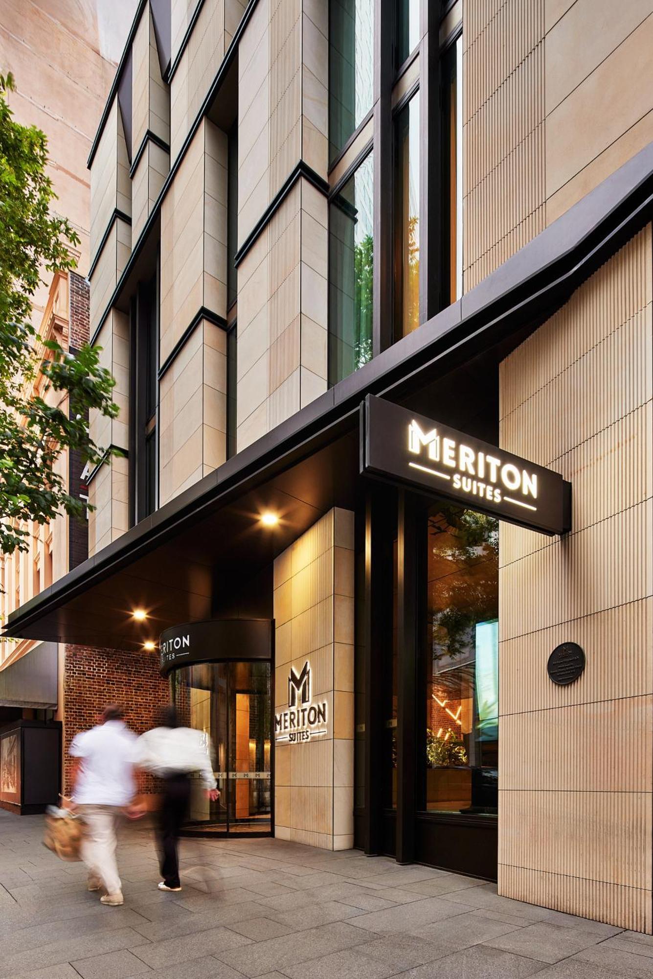 Meriton Suites Sussex Street, Sydney Ngoại thất bức ảnh The photo shows the exterior of a building with the signage for "Meriton Suites." The entrance features a modern design, with sleek architectural elements and large windows. The entrance is highlighted by a prominent awning and illuminated signs, ind